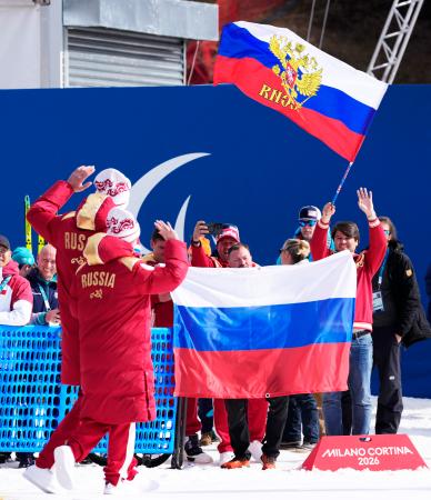 ノルディックスキー距離女子２０キロ視覚障害で金メダルを獲得し、表彰式に向かうロシア選手と喜ぶ関係者＝１５日、イタリア・テーゼロ（共同）