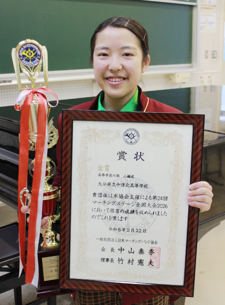 金賞の賞状とトロフィーを持つ別府七実部長