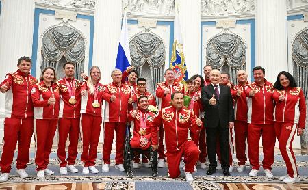 ミラノ・コルティナ冬季パラリンピックに出場したロシア選手らと写真に納まるプーチン大統領（右から５人目）＝１９日、モスクワ（ロシア大統領府提供・共同）