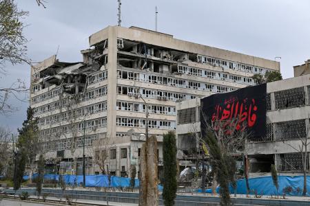 ミサイル攻撃を受けたイラン司法当局の建物（左）と隣接する警察署＝２０日、テヘラン（共同）