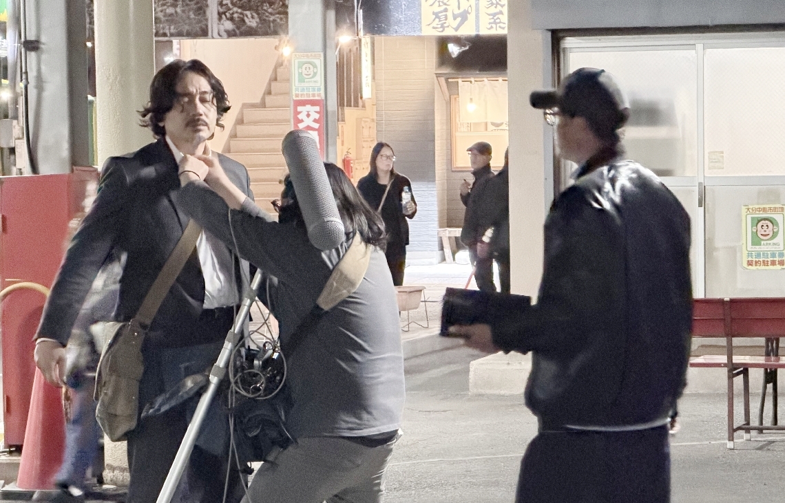 撮影に臨む主演の青柳翔（左）＝２４日夜、大分市内