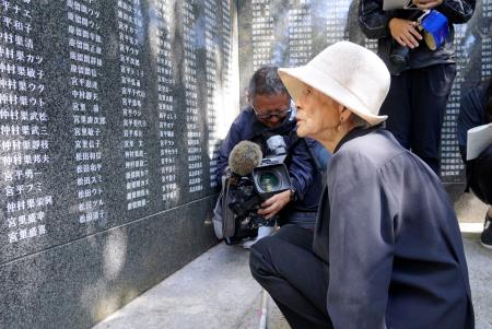 米軍上陸から８１年となり、犠牲者の名前が刻まれた石碑を見つめる女性＝２６日午前、沖縄県・座間味島