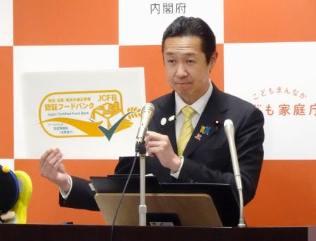 「フードバンク」事業に関し、国の認証を受けた団体に使用を許可するロゴマークを掲げる黄川田消費者相＝２７日午前、東京都千代田区