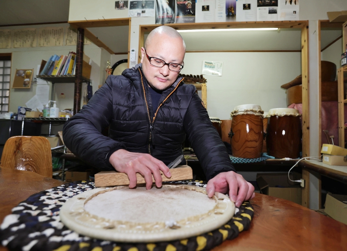 締め革の仕上げ作業をする河野剛士さん＝２３日、由布市湯布院町の太鼓工房「響屋」