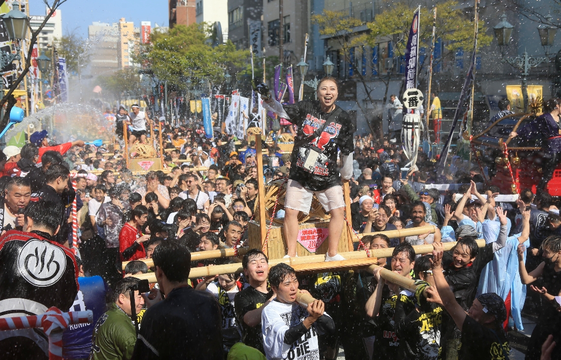 「第１１２回別府八湯温泉まつり」が４月１日に開幕。２０２５年の「湯ぶっかけまつり」で大量の湯を浴びながら練り歩くみこし＝別府市の別府駅前通り