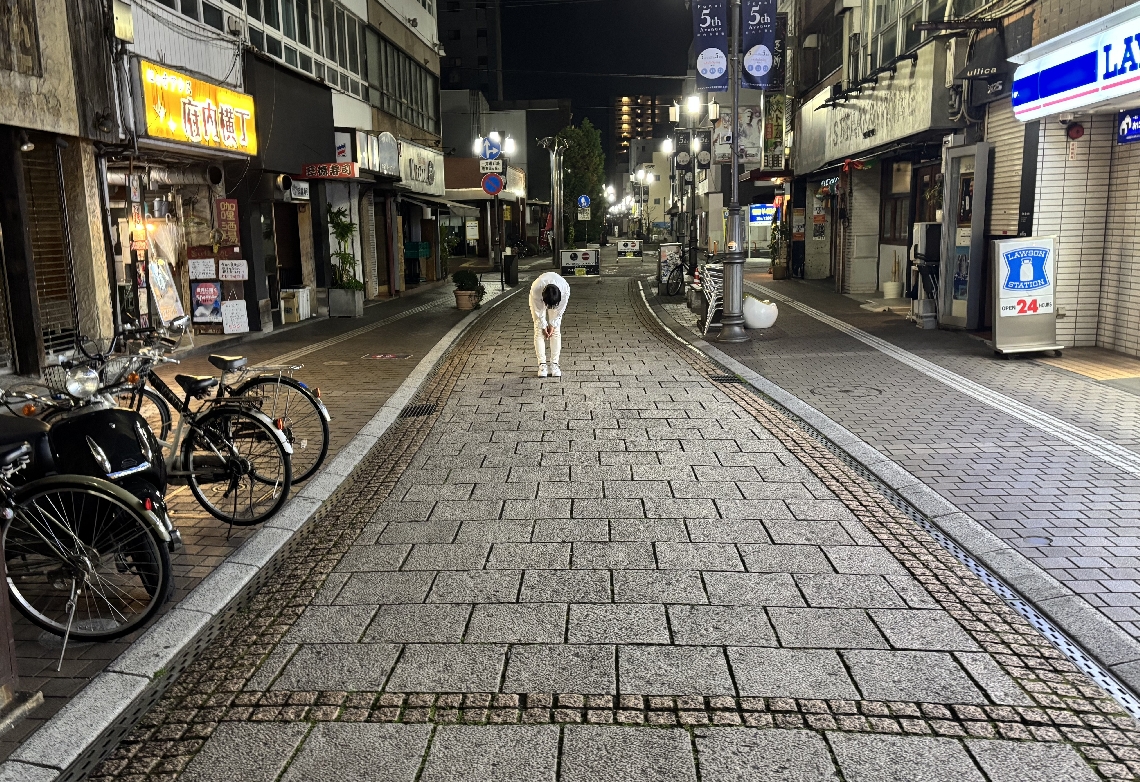 深々と頭を下げて客を見送る大分市府内町のスナック「Ｂ面」の池永猛店主＝３月２８日夜