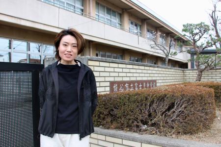 通級指導教室の支援員として働いた母校の前に立つ新井麻衣良さん＝埼玉県熊谷市