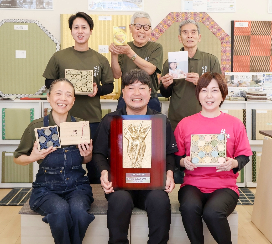 グランプリ獲得を喜ぶ佐々木社長（前列中央）と従業員ら