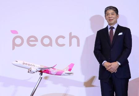 刷新したロゴマークと機体デザインを発表するピーチ・アビエーションの大橋一成最高経営責任者＝３１日午後、大阪市北区
