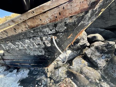 鳥取県湯梨浜町の海岸に漂着した木造船。外板にハングルが記載されている＝３日（境海上保安部提供）