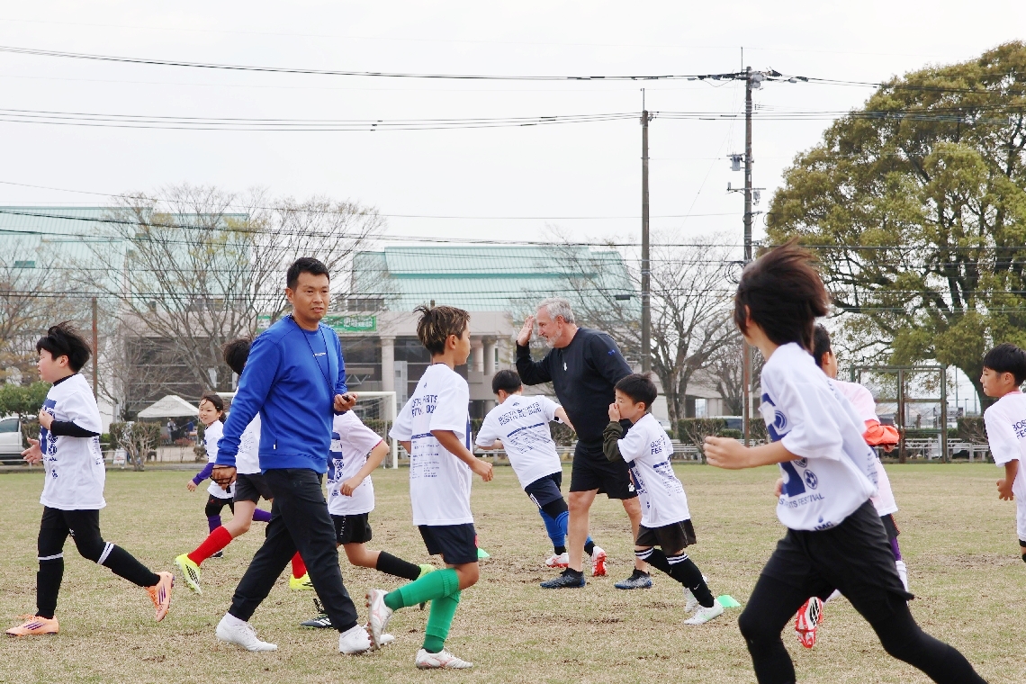 トレーニングを前に軽い運動で汗を流すサッカーの選手たち＝恵藤建設サン・スポーツランド