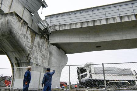 大阪府羽曳野市の南阪奈道路で、高架の壁を突き破って転落したダンプカー＝７日午後１時４７分