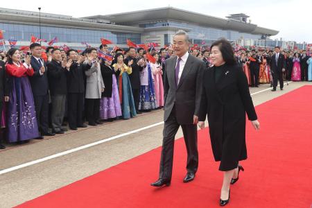 平壌国際空港で北朝鮮の崔善姫外相（手前右）と肩を並べて歩く中国の王毅外相＝９日（共同）