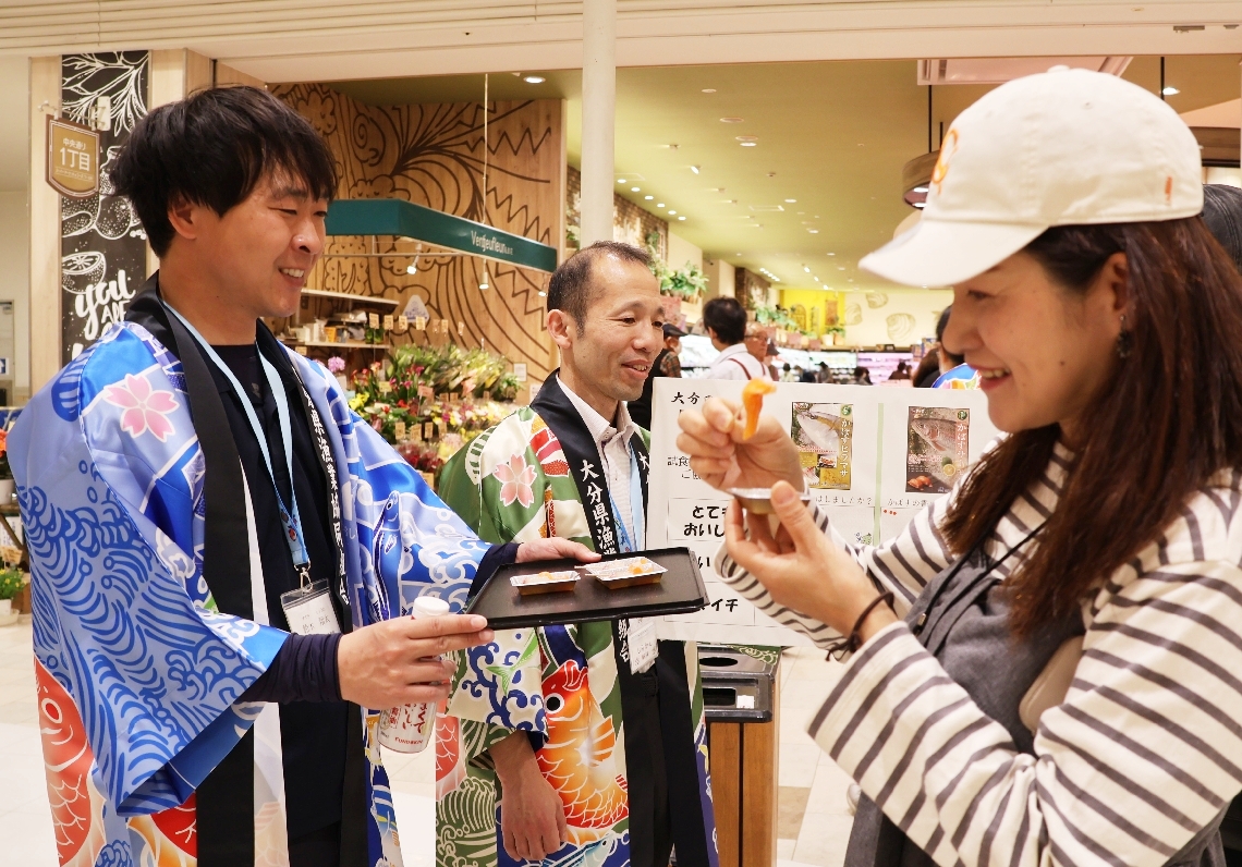 「かぼすサーモン」を試食する買い物客（右）ら