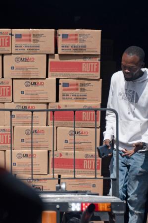 コンゴの首都キンシャサ郊外の倉庫から運び出されるＵＳＡＩＤの支援物資＝２０２５年４月（共同）