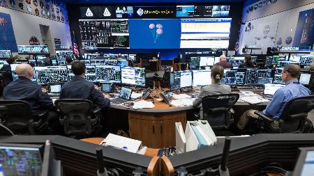 パラシュートを開いた宇宙船オリオンの着水を見守る管制担当者ら＝１０日、米テキサス州ヒューストンのジョンソン宇宙センター（ＮＡＳＡ提供）