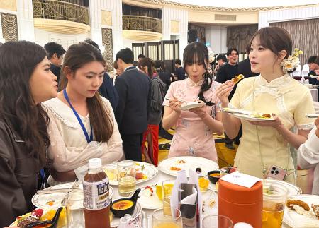 中国人学生と会話を楽しむチャイナドレス姿で参加した日本の留学生＝１１日、中国上海市（共同）