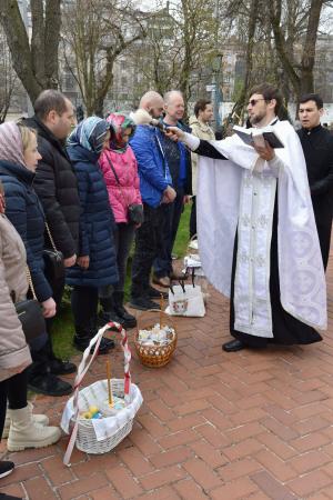 キーウの聖ソフィア大聖堂で、市民に聖水をかける聖職者（右手前）＝１２日（共同）