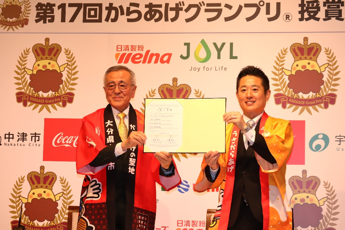 「カラアゲシティプロジェクト」の共同宣言書に署名した中津市の奥塚正典市長（左）と宇佐市の後藤竜也市長