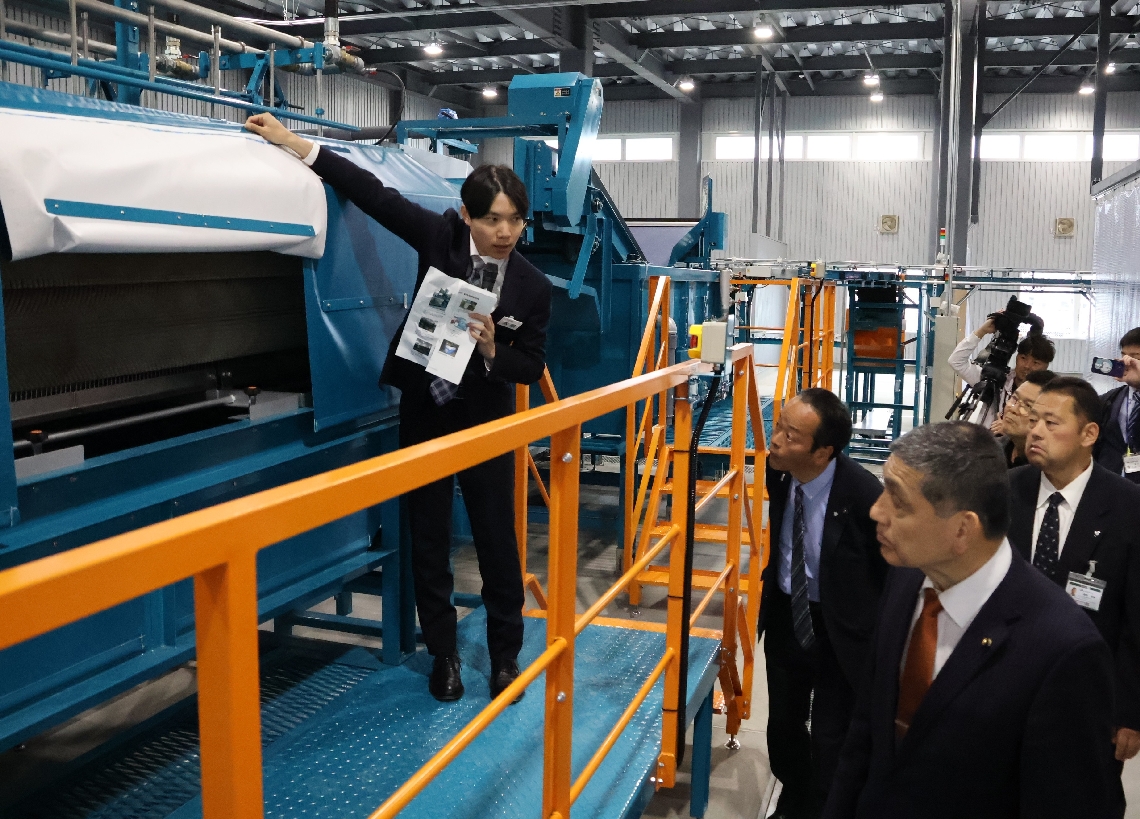 最新の洗浄機などの説明を受ける関係者