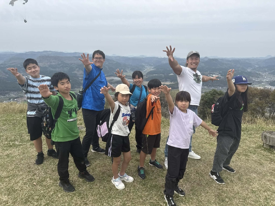 全員で上村優也選手の「太陽のポーズ」で記念撮影＝４月１２日、玖珠町