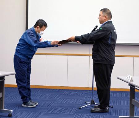 原子力規制委側から「使用前確認証」を受け取る東京電力柏崎刈羽原発の稲垣所長（左）＝１６日午後、新潟県刈羽村