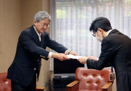 抗議文を提出する市民団体「教科書問題を考える市民ネットワーク・ひろしま」の岸直人さん（左）＝１７日午後、広島市