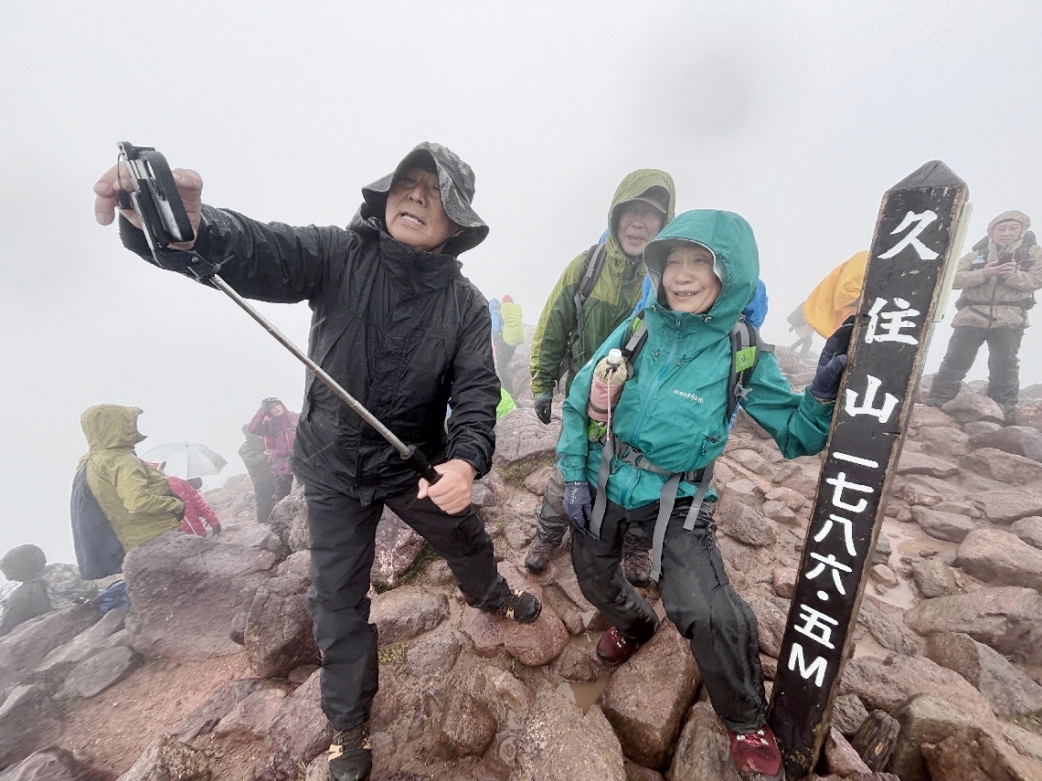 山頂で記念撮影する登山者