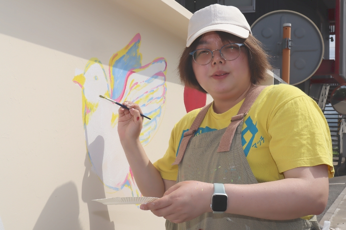白く塗り直したレノン・ウォールにイラストを描き始めたこっちゃん