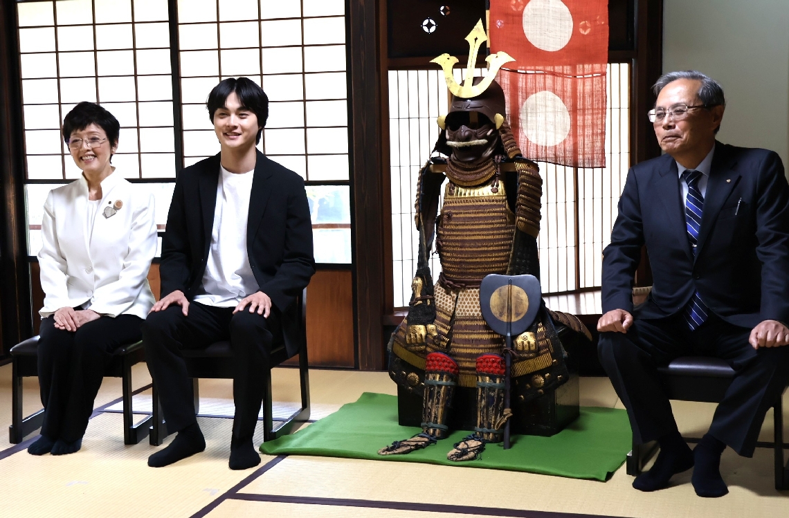豊臣秀長のものとされるよろいを挟み、鼎談した（左から）椋野美智子市長、結木滉星さん、草野義輔さん