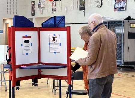 ２１日、米バージニア州アーリントンで、住民投票に参加する人たち（共同）