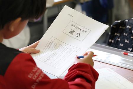 全国学力テストで問題用紙を手に開始を待つ児童＝２３日午前、東京都内の小学校（代表撮影）