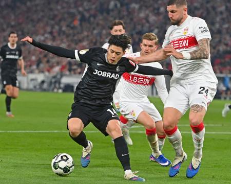 シュツットガルト戦で競り合うフライブルクの鈴木（左）＝シュツットガルト（共同）