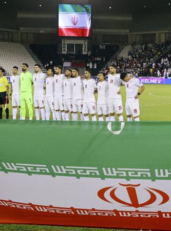 ２０２５年６月、サッカーＷ杯アジア予選カタール戦を前に国歌を聞くイラン代表＝ドーハ（ロイター＝共同）