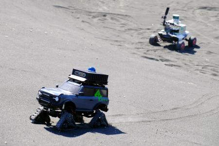 月面を再現した研究拠点で、クレーターの斜面を走行する探査車＝２月、福島県南相馬市