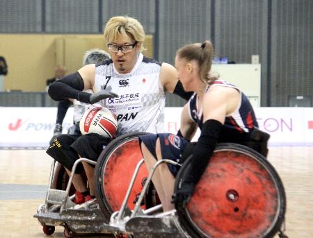 車いすラグビーのジャパンパラ大会の米国戦で攻め上がる池崎（左）＝千葉ポートアリーナ