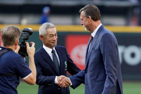 マリナーズの本拠地Ｔモバイル・パークで行われた、永久欠番を祝福する式典でランディ・ジョンソンさん（右）と握手するイチローさん＝２日、シアトル（ロイター＝共同）