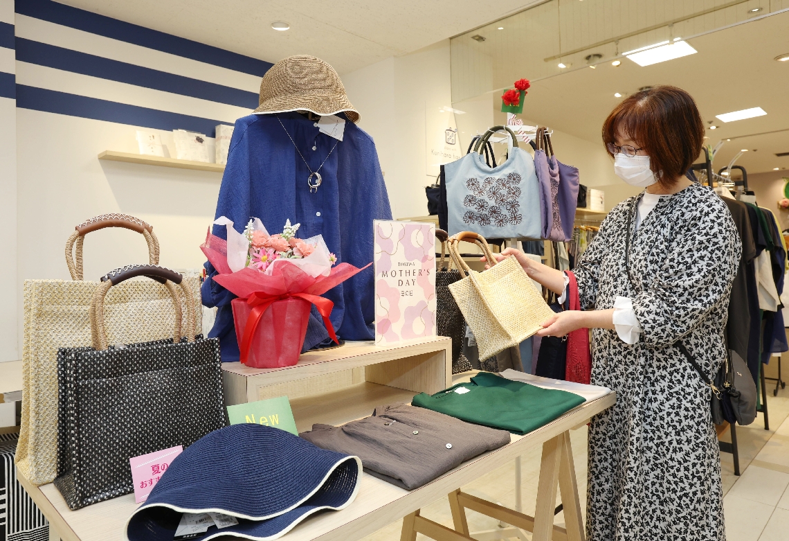 母の日コーナーの商品を手に取る買い物客