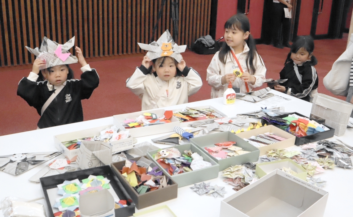 飾り付けた紙製かぶとをかぶって楽しむ子どもたち＝大分市のコンパルホール