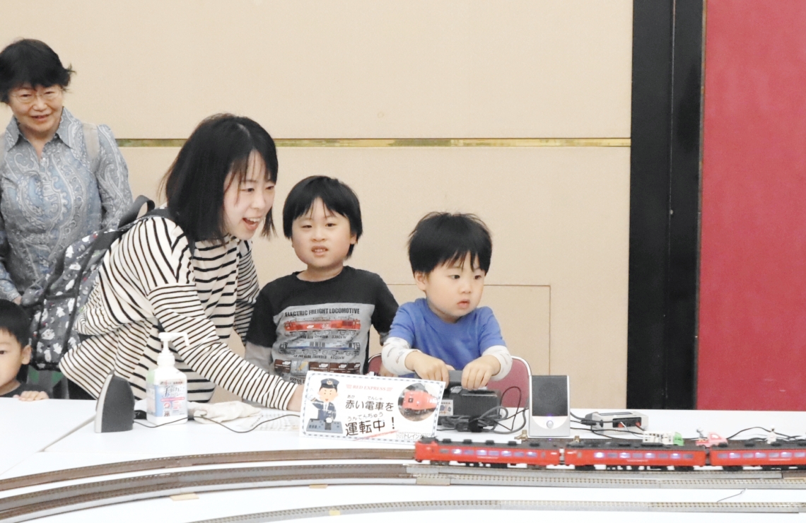 鉄道模型をレバーで操作し楽しむ親子連れ＝大分市のコンパルホール