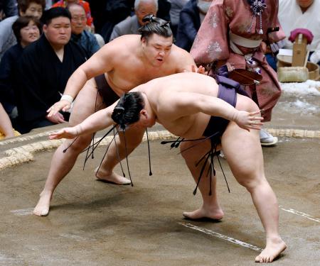 霧島（奥）が突き落としで義ノ富士を下す＝両国国技館