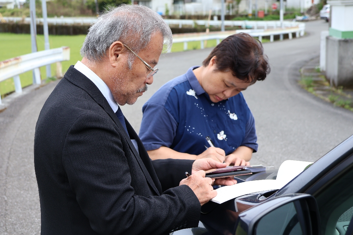 不在だった加害者の男性に手紙を書く井上保孝さん（左）と郁美さん＝４月、高知県内