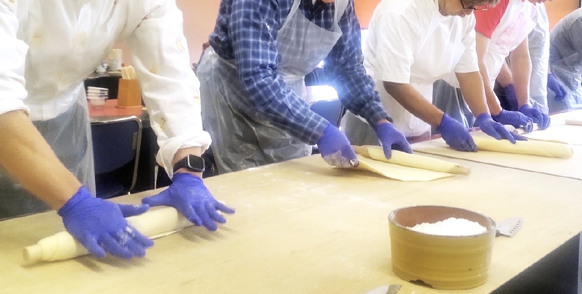 うどん道場で、麺棒を使って生地を延ばす参加者の手つき