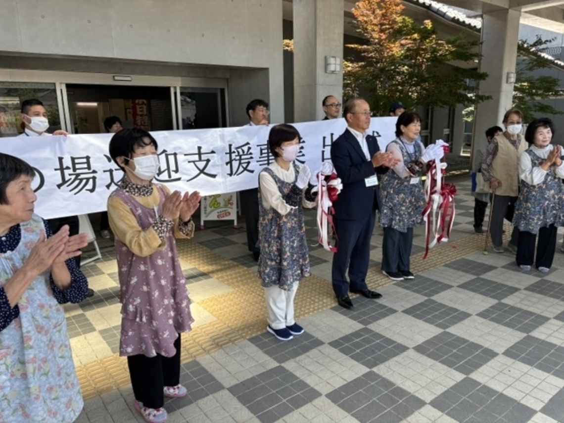 送迎車を拍手で見送る関係者