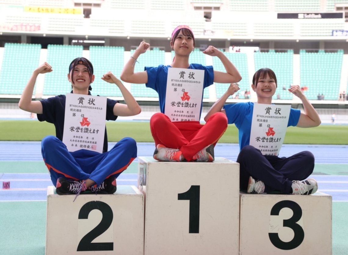 【女子やり投げ決勝】表彰台でポーズをとる杵築の広岡（中央）、雄城台の広瀬（左）と国東の伊藤