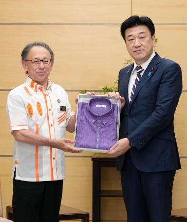 沖縄県の玉城デニー知事（左）から「かりゆしウエア」を贈呈される木原官房長官＝２２日午前、首相官邸