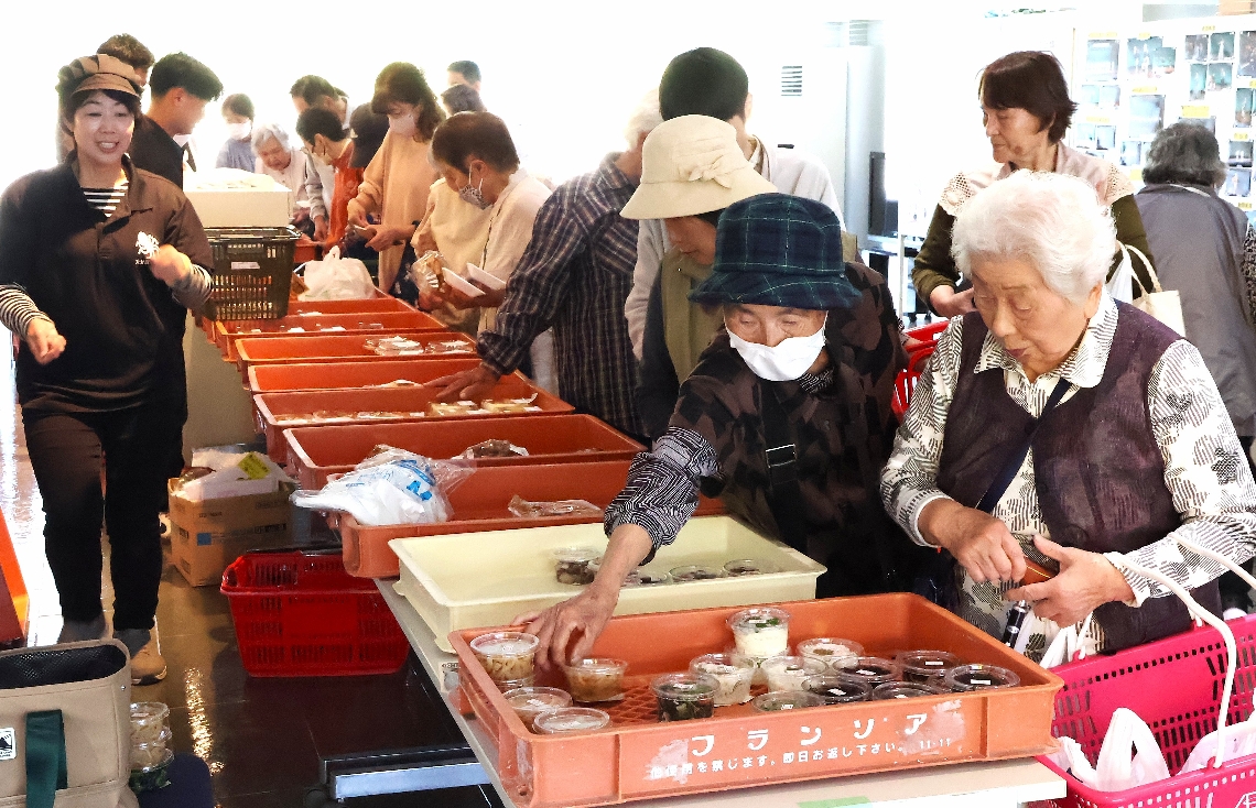 買い物マーケットで生鮮食品などを買い求める地域住民