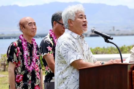 ２４日、米ハワイの真珠湾で開かれた式典であいさつする佐々木住幸さん。左端は雅弘さん（共同）
