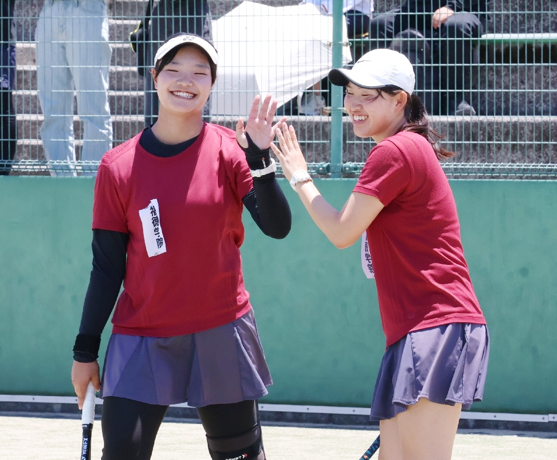 【テニス女子団体決勝・福徳学院―豊府】ポイントを取って笑顔を見せる福徳学院の田中主将（左）と横地＝クラサスコート
