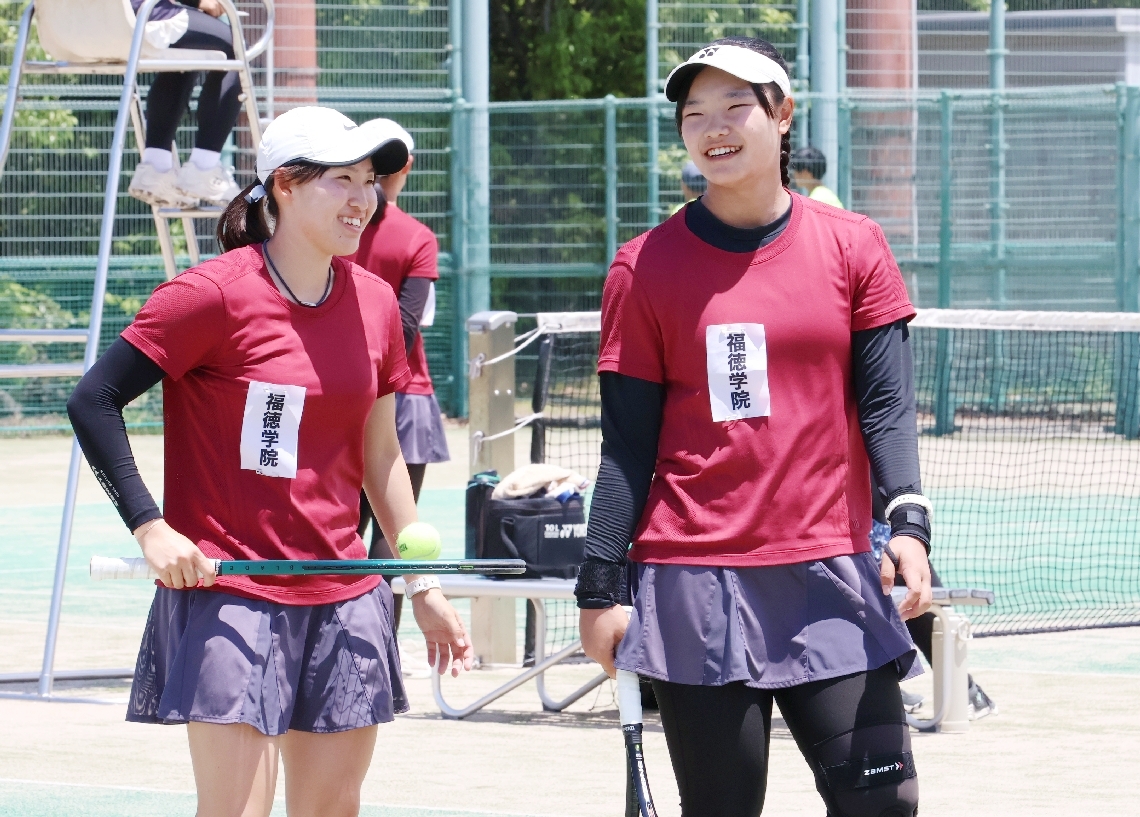 【テニス女子団体決勝・福徳学院―豊府】ポイントを決めて笑顔を見せる福徳学院の田中主将（右）と横地